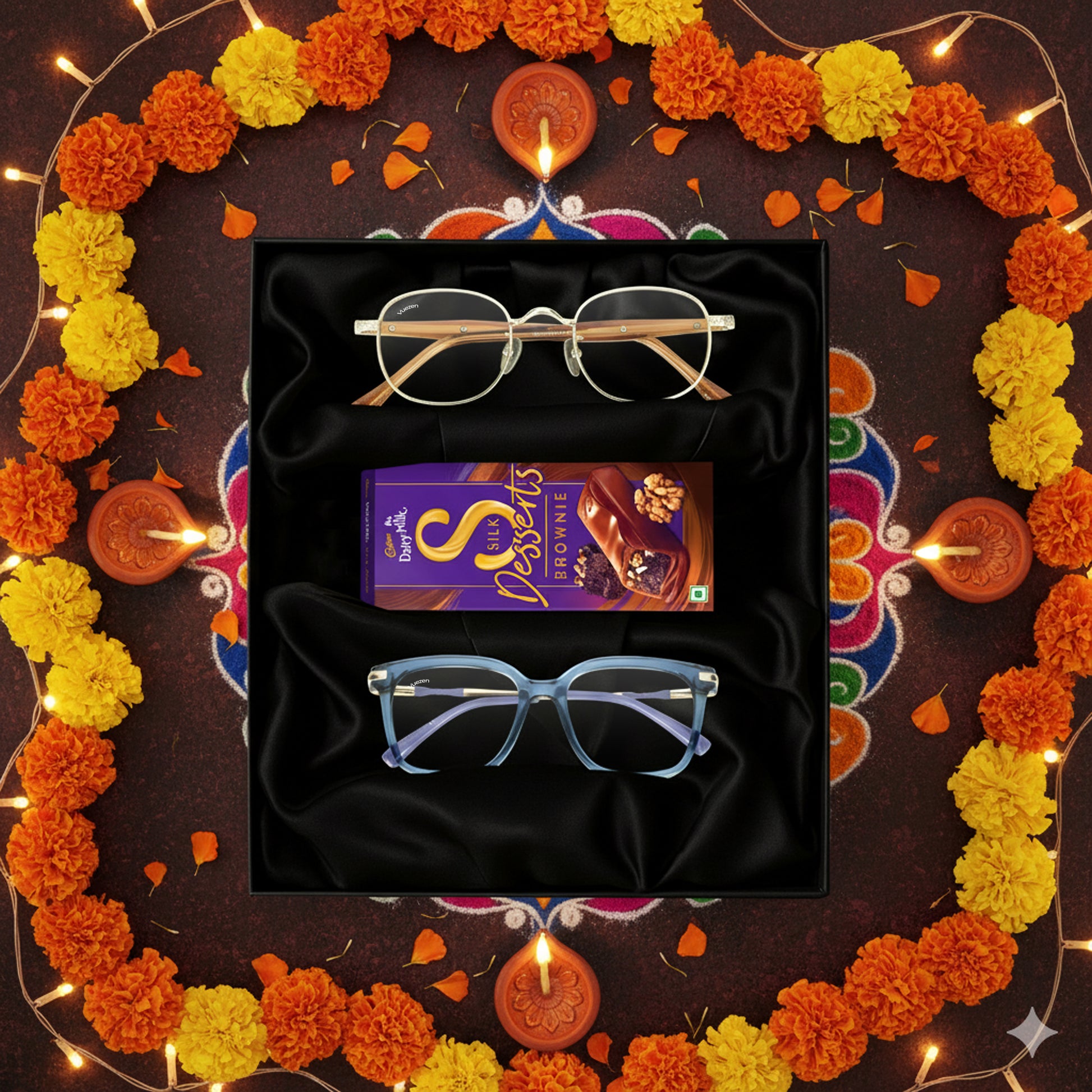 Decorative setup with glasses, a box of chocolates, and marigold flowers